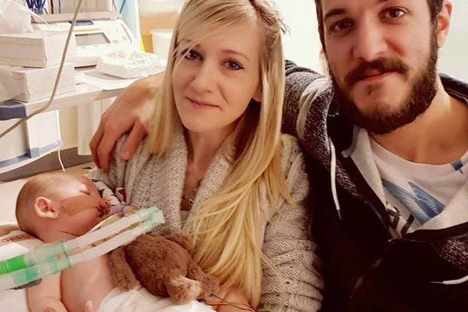 Родители малыша Чарли Гарда с ребенком на руках.