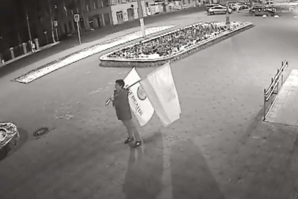Один из грабителей взял флаги и торжественно начал размахивать ими. Фото: скриншот с видео
