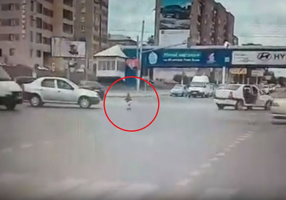 Кадр из видео: ребенок упал на асфальт на оживленном перекрестке.
