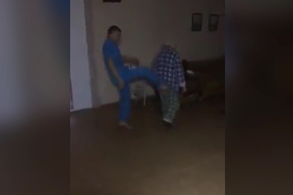 Кадр из видео: санитары глумятся над пожилым пациентом больницы.