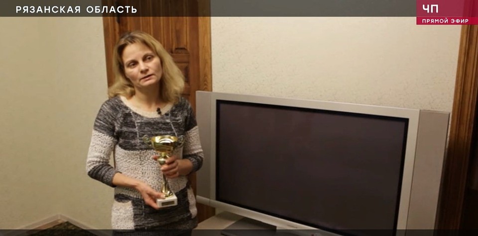 Кадр из телесюжета: мать потерпевшего с его спортивной наградой в руках