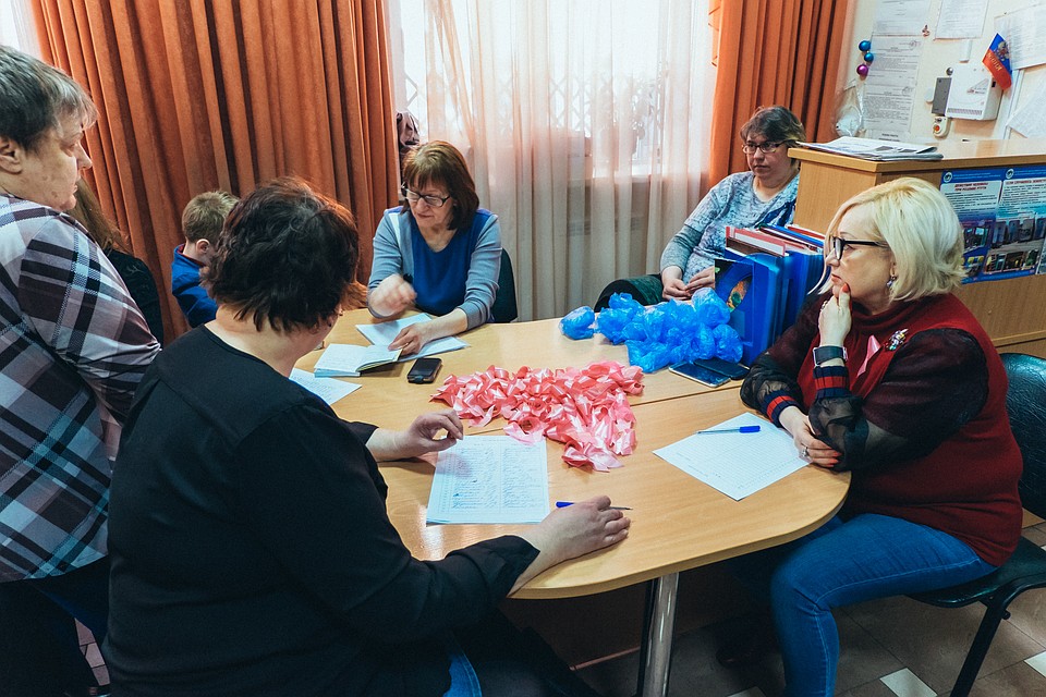 На столе организаторов розовые ленточки - символ борьбы против рака молочной железы.