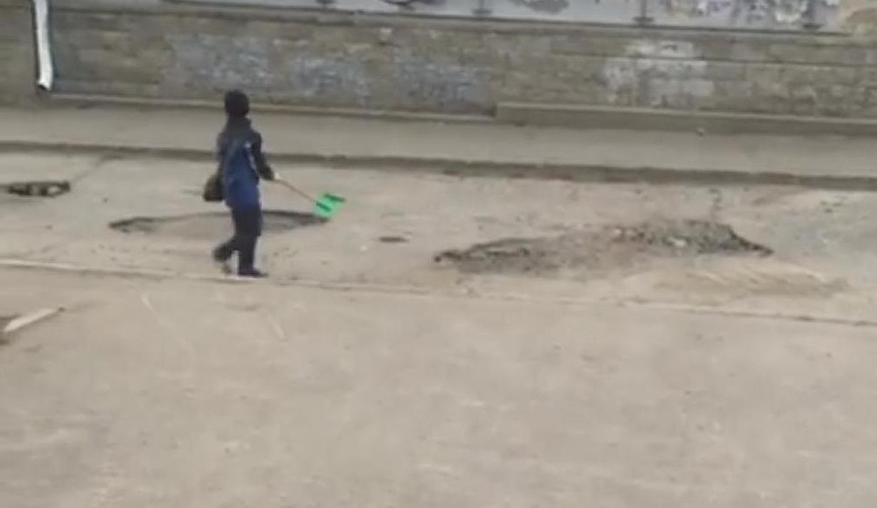 В Омске сняли на видео ребенка, латающего ямы на дороге детской лопаткой