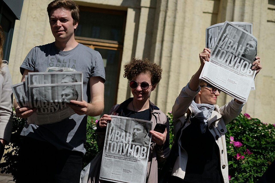 Журналисты раздают и читают вслух газеты и стоят в одиночных пикетах.