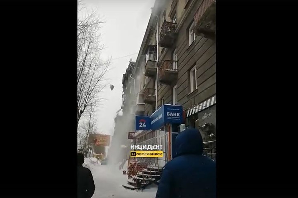 Новосибирцев возмутили рабочие, сбрасывающие снег с крыши дома прямо на прохожих. Фото: Кадр из видео
