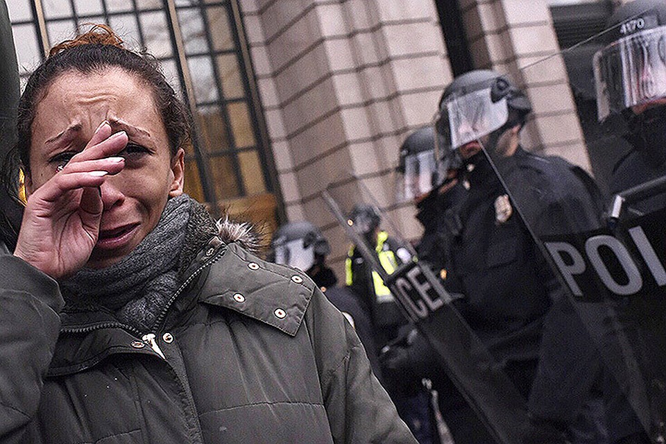 Противница Дональда Трампа у рядов щитов полицейского спецназа в Вашингтоне.