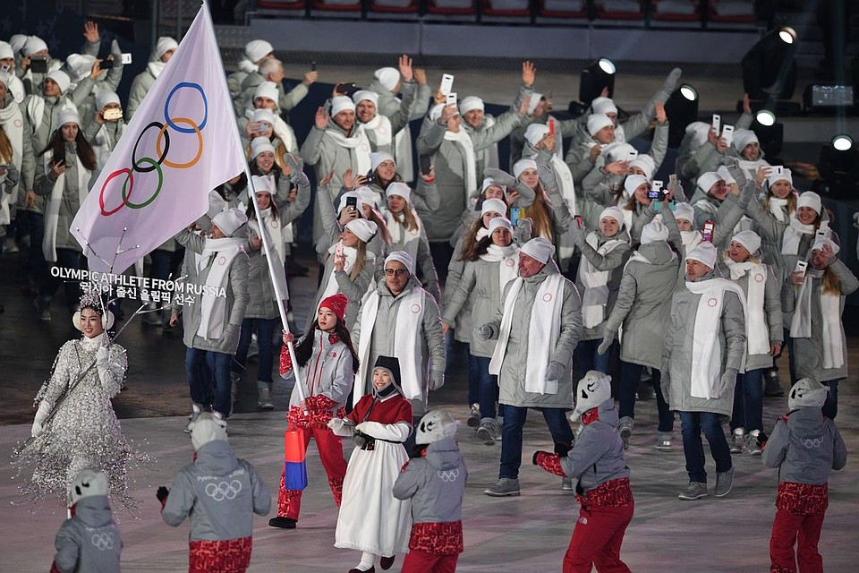 Российская сборная шла под нейтральным олимпийским стягом, который несла девушка-волонтер. Фото: AFP