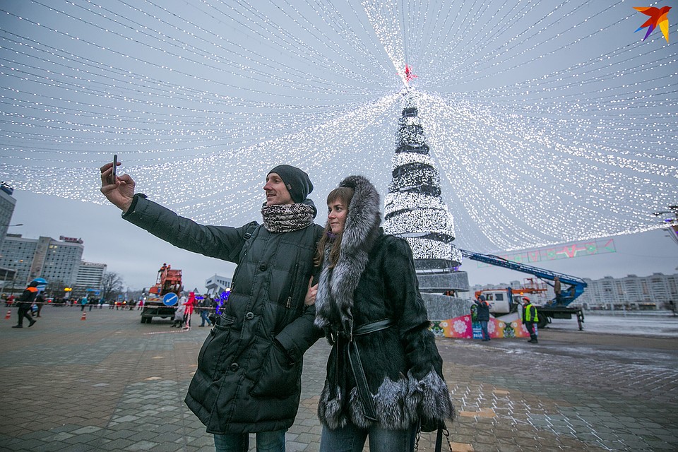 Прохожие с удовольствием фотографируются на фоне елки. Фото: Павел МАРТИНЧИК