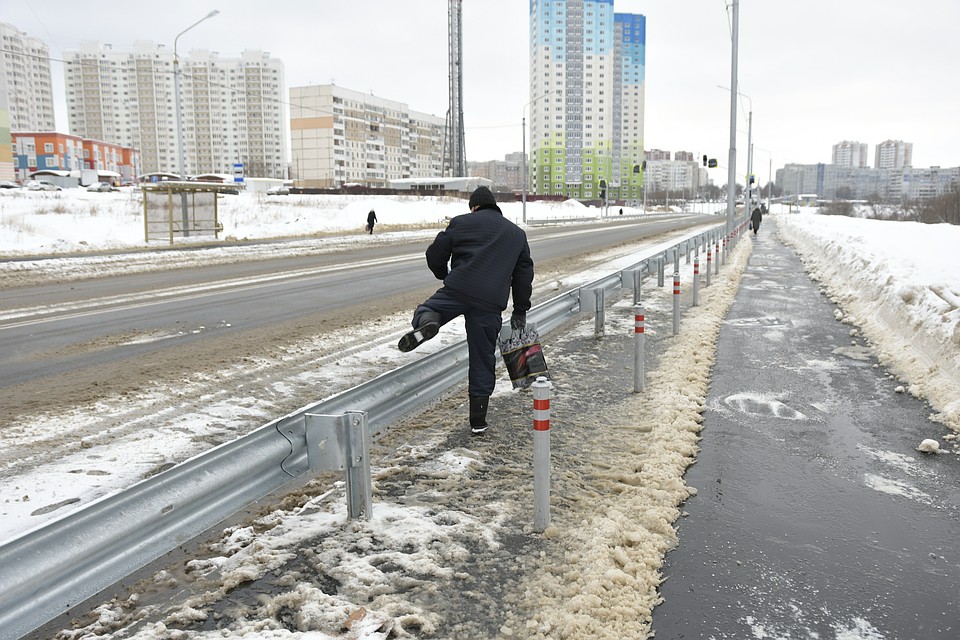 Туляки переходят проезжую часть, перелезая через отбойники
