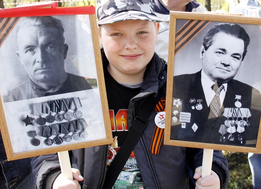 На траурный митинг в Кохтла-Ярве дети и взрослые приносят портреты своих героев. Фото: Евгений КАПОВ