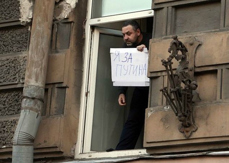 Настоящими «рассерженными горожанами» оказались те, кого уже начали доставать митинги протеста. 4 февраля - одиночный оконный пикет жителя Петербурга во время прохождения по его улице толпы оппозиции. Фото Тимура ХАНОВА («КП» - Санкт-Петербург»).