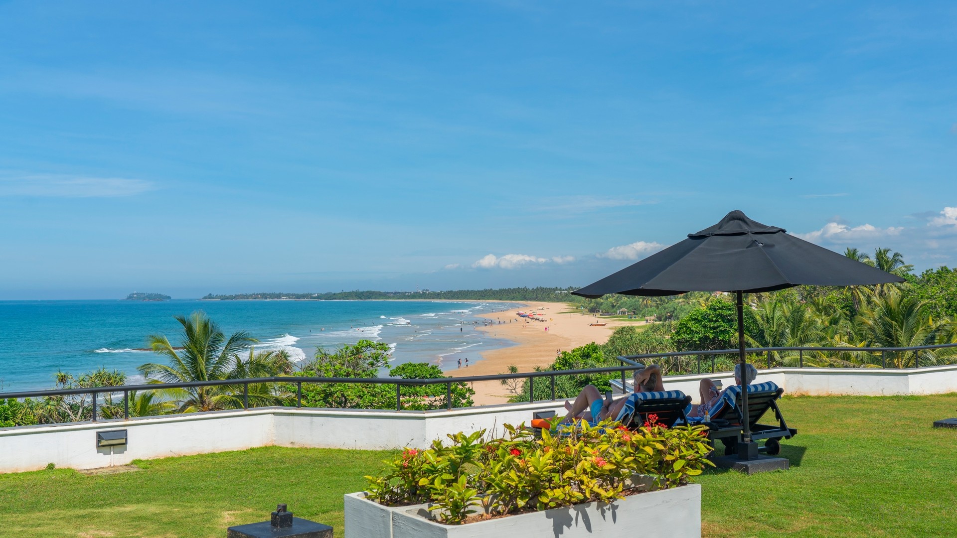 Пара любуется пляжем с пальмами и Индийским океаном в Бентоте.