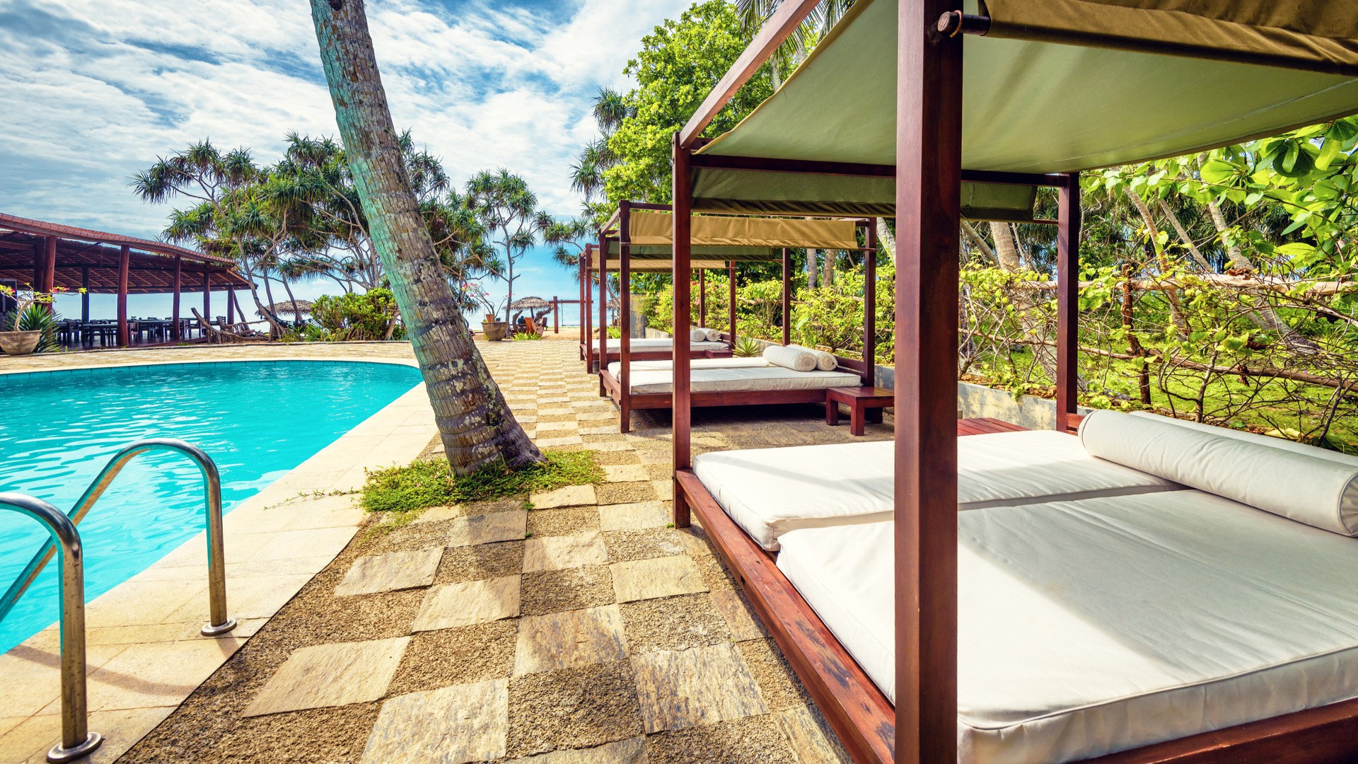 Роскошные свободные шезлонги и бассейн на тропическом курорте Тангалле.